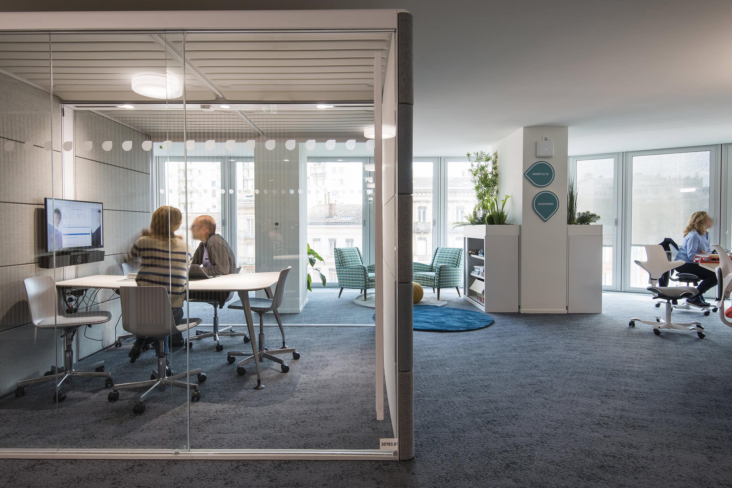 Personnes travaillant dans un bureau vitré