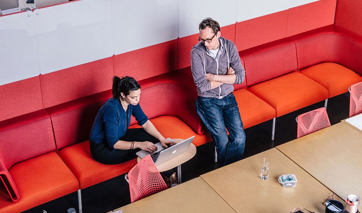 2 personne discutant sur un fauteuil rouge